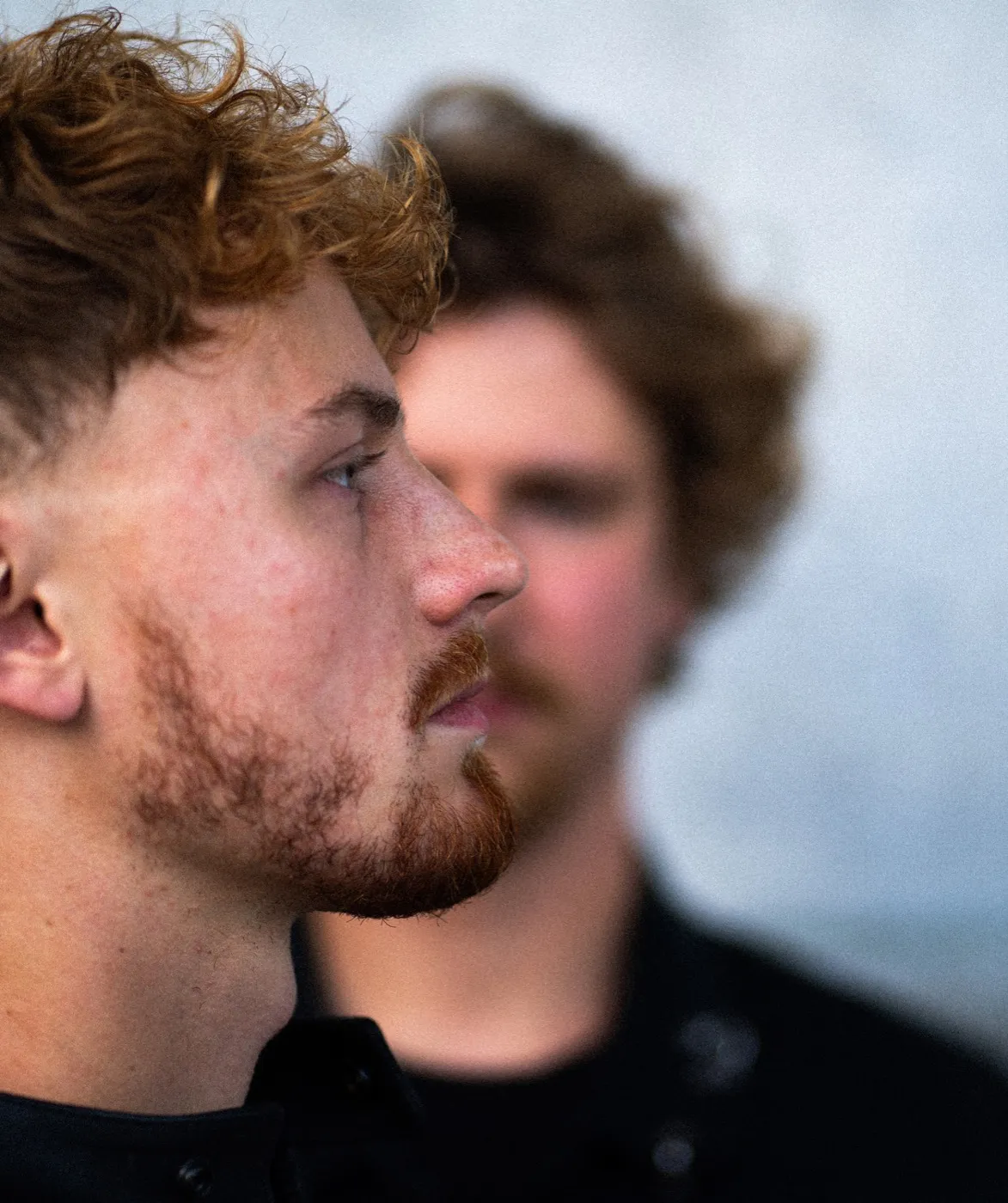 Vertical portrait of both musicians in profile, one behind the other