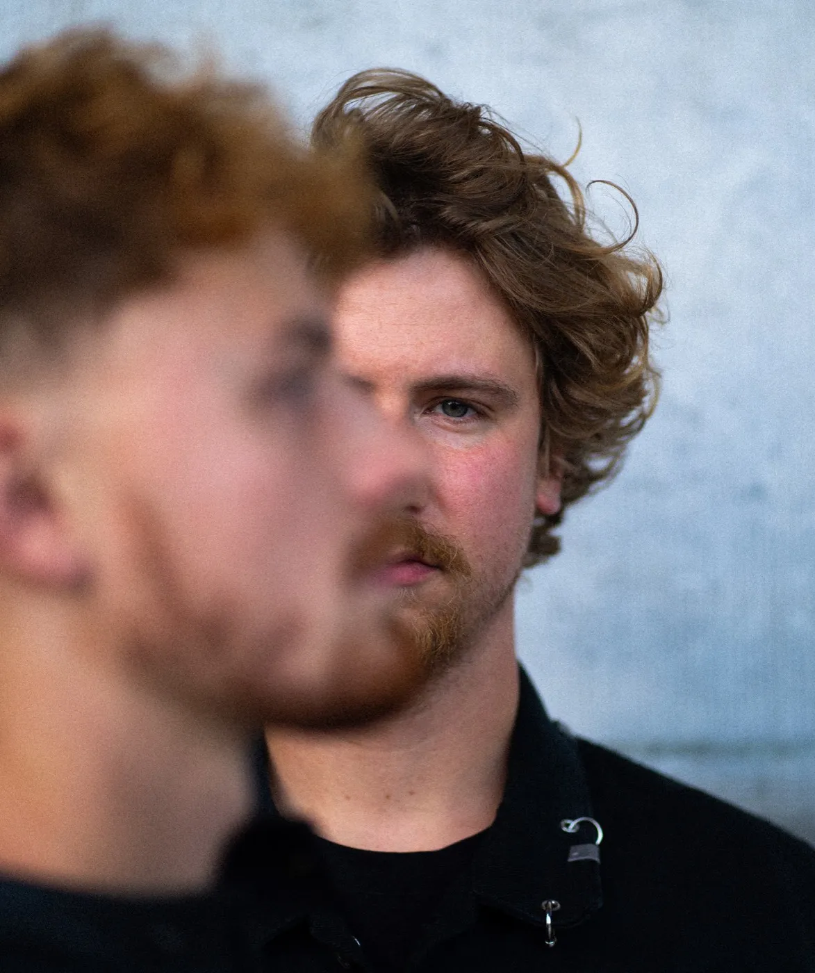 Close portrait of the duo, one face in focus behind a blurred foreground