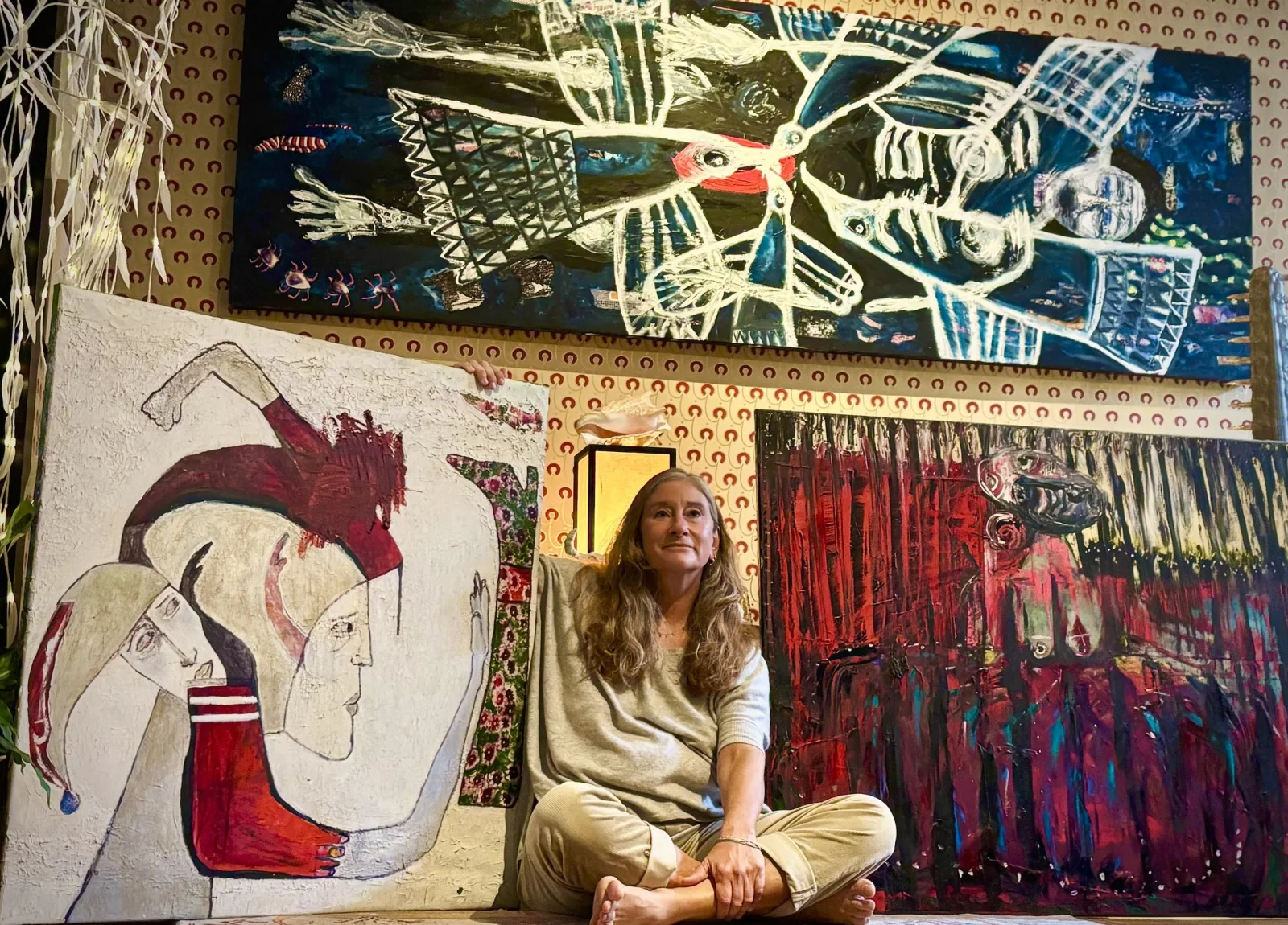 Julie Ghenet seduta tra le sue opere